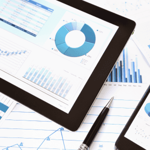 Historical Form 5500 data analysis charts and graphs displayed on tablet with business reports and pen